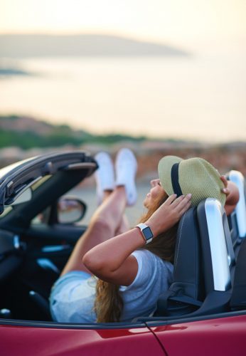 Female traveller enjoying convertible car during the summer in Italy